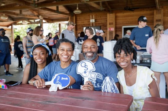 family posing for a photo at a table holding georgia southern football swag