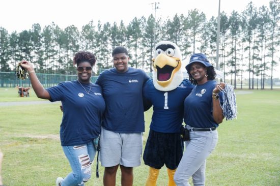 a family posing to take a photo with gus the eagle mascot